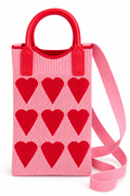 Front view of a pink knit purse with red hearts, red top handles, and a pink shoulder strap